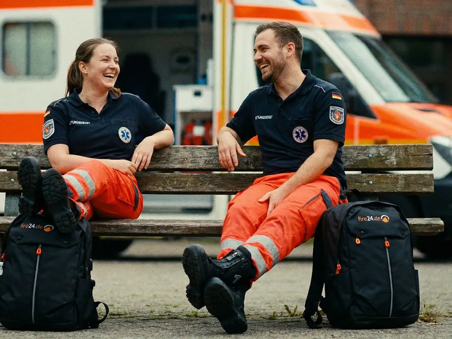 Zwei Rettungskräfte mit fire24-Rucksäcken vor dem Rettungswagen